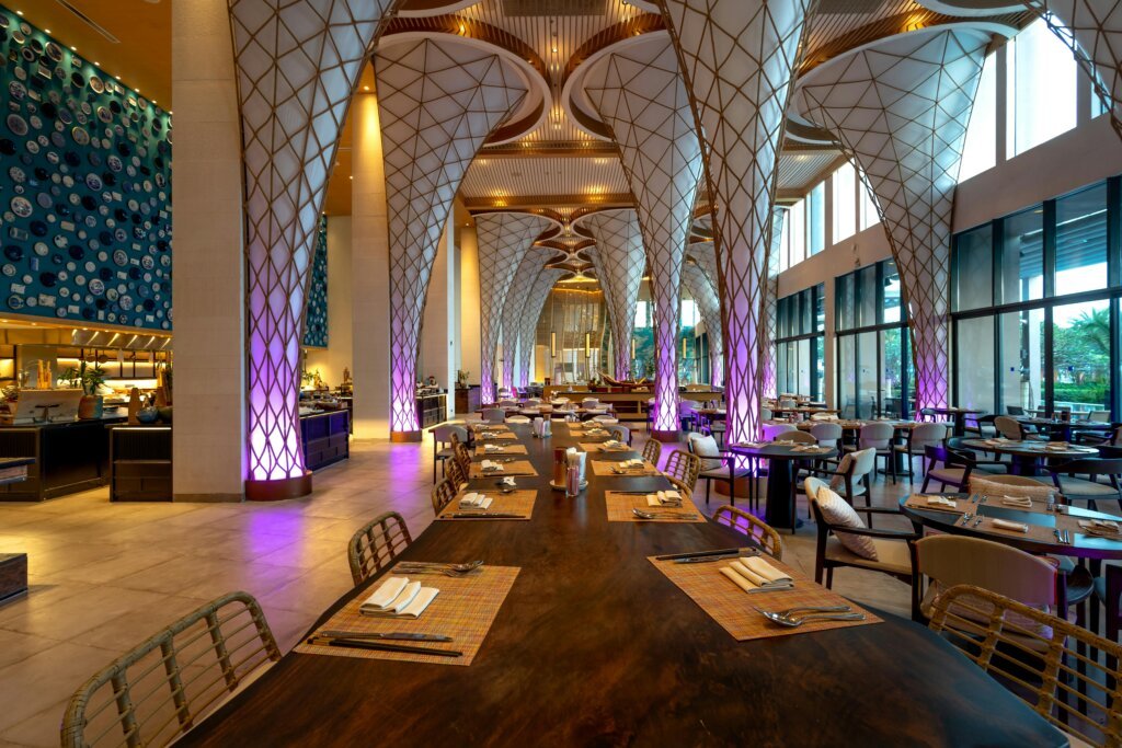 Spacious modern restaurant interior with unique ceiling design and ambient lighting.
