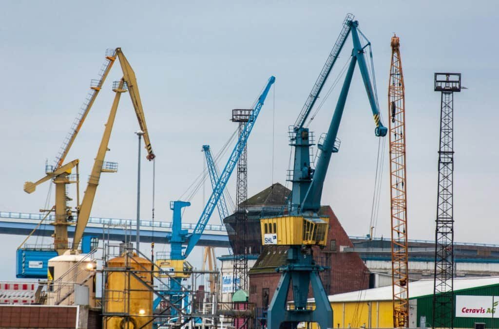 Colorful cranes in a bustling industrial harbor, showcasing maritime construction activity.