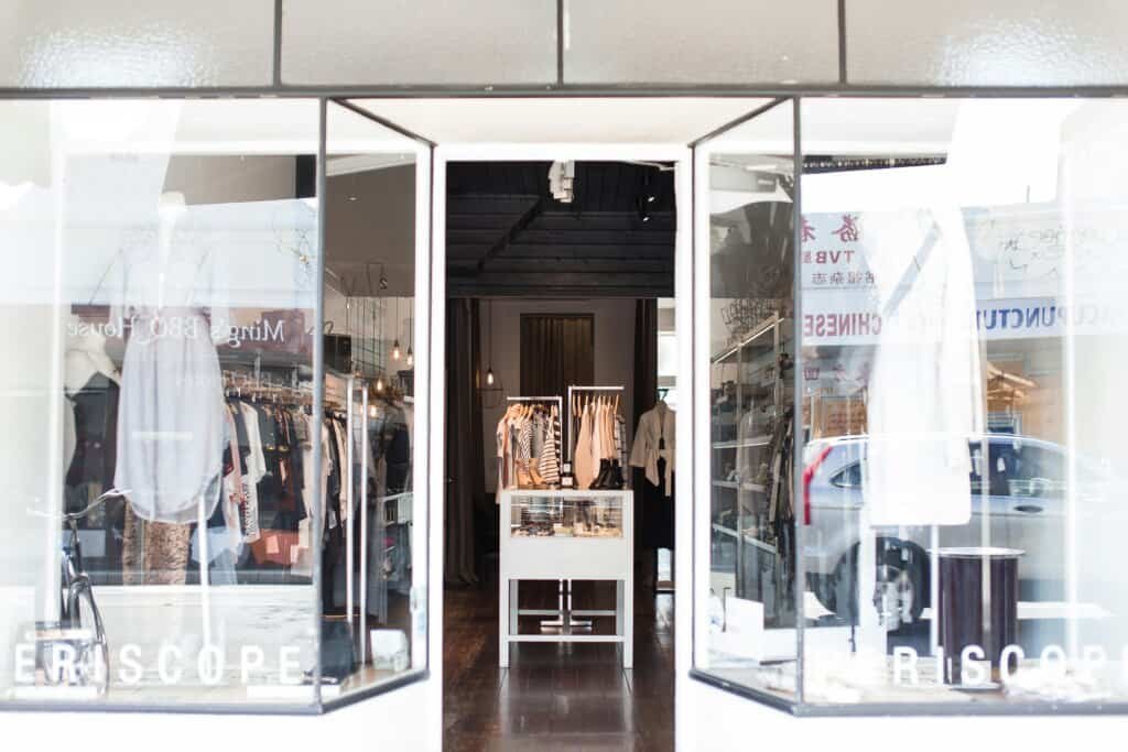 Entrance to a chic clothing boutique with stylish window displays and curated apparel.